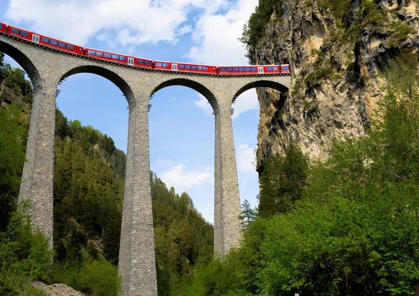 Red train crossing the Landwasser Viaduct in Switzerland